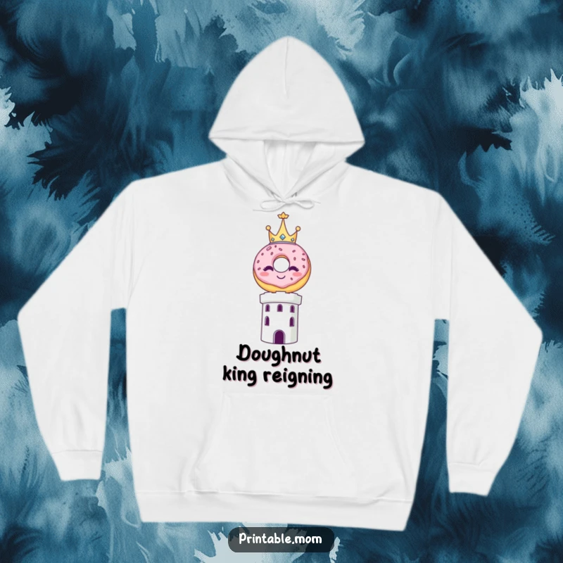 Funny hoodie featuring a smiling donut wearing a miniature crown, elevated atop a towering structure.