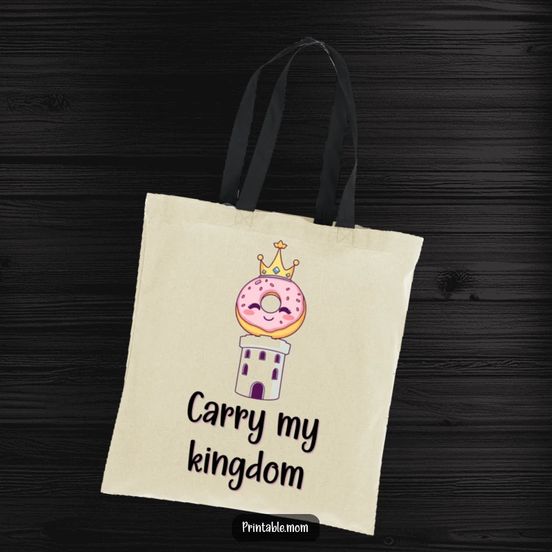 Funny tote bag depicting a smiling donut wearing a tiny crown, balanced triumphantly on top of a tower.